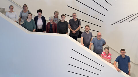 ein Teil der HLGL Mitarbeiter:innen auf der Treppe im Foyer der Leica-Welt in Wetzlar