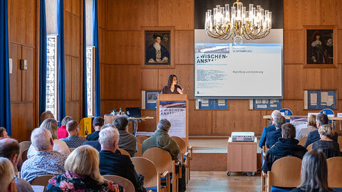 Staatsministerin Dorn bei der Begrüßung der Teilnehmer*innen der Tagung Staatsministerin Dorn am Rednerpult im Landgrafensaal des Staatsarchivs Marburg