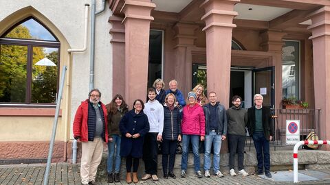 Das Team des Forschungsprojekts zur NS-"Euthanasie" und die Mitglieder des Gedenkort Kalmenhof e.V. vor dem Portal des Gebäudes.