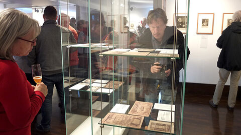 Gäste betrachten die Ausstellungsstücke in den Vitrinen